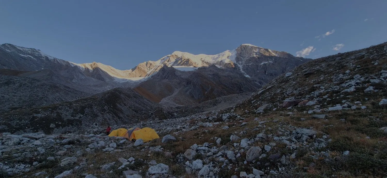 Yellow expedition tents beneath snow-covered Himalayan peaks